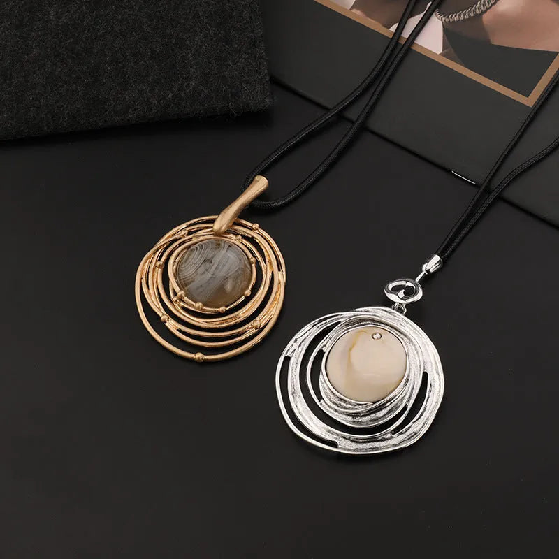 Large round gold geometric pendant on a long adjustable snakeskin rope chain necklace for sweaters