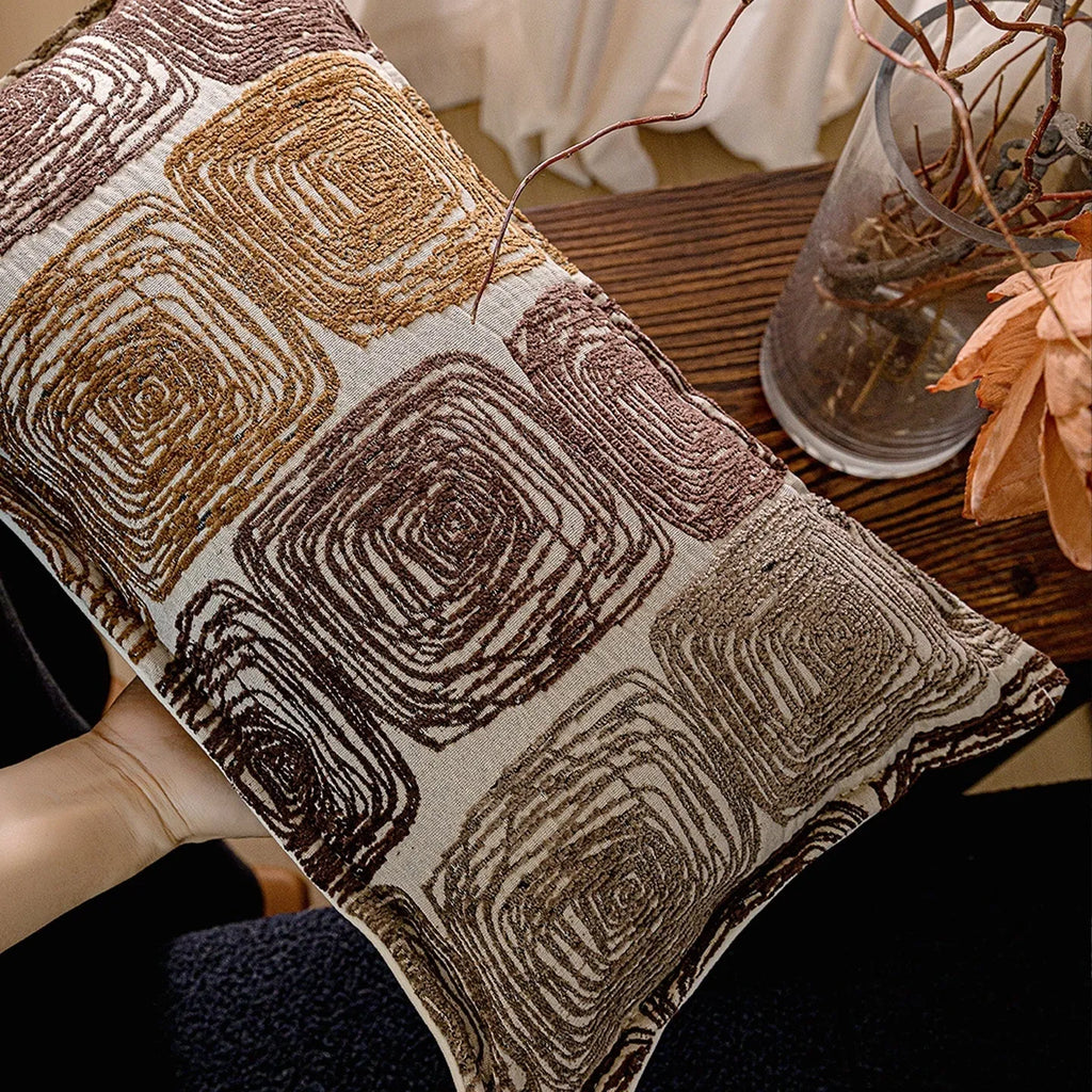 Cream and coffee-coloured abstract coil pattern printed on square polyester velvet pillow cover