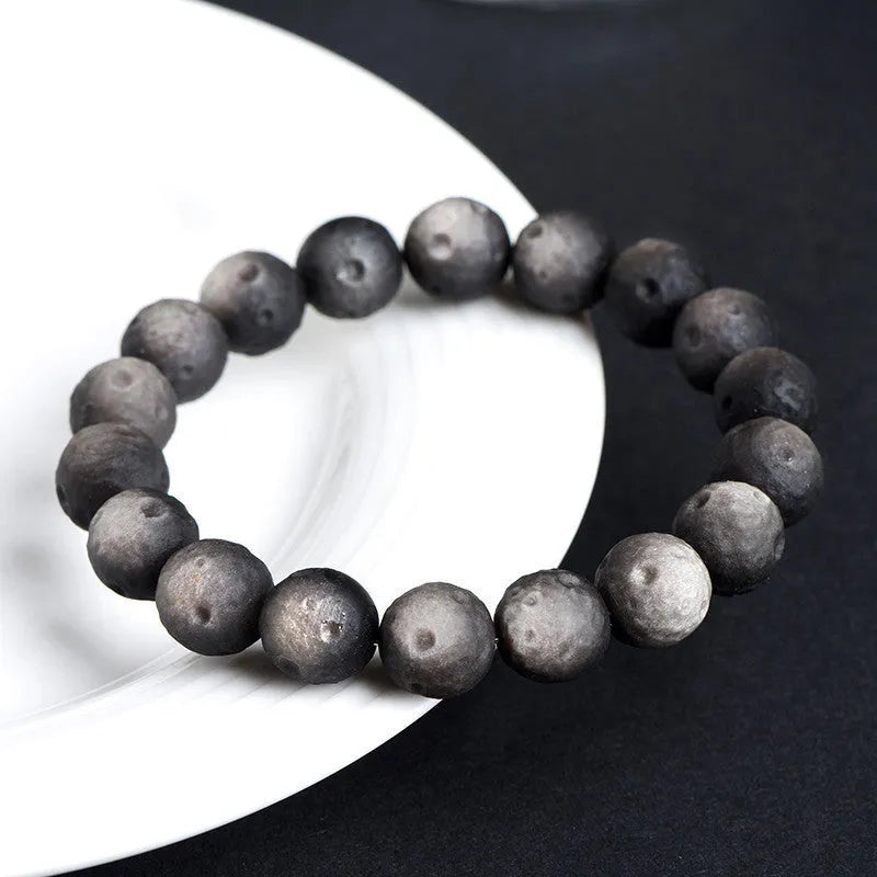 Obsidian meteorite crater ball bracelet with polished stones on adjustable string