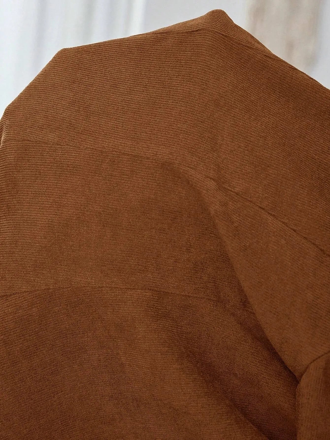Brown single-breasted leisure blazer with lapel collar and long sleeves on a hanger.