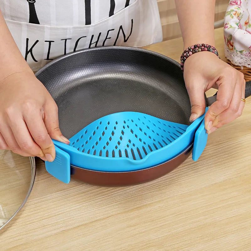 Silicone clip-on kitchen strainer attached to pot rim draining liquid