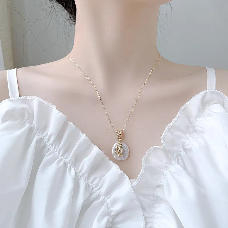 Women's baroque shaped pearl ornament necklace and earrings set with geometric O-ring chain on display