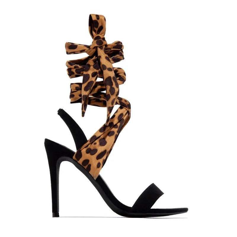 Light brown women's high heels with leopard print pattern and cross strap detail on the foot.