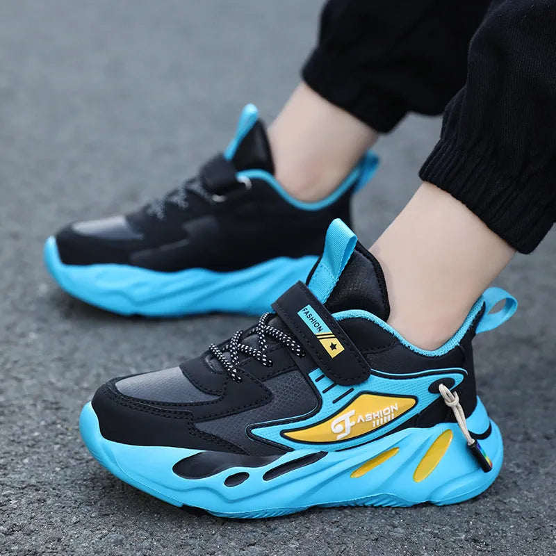 Boys sports running shoes in dark blue with a mesh upper and Velcro strap, shown on a hard ground surface.