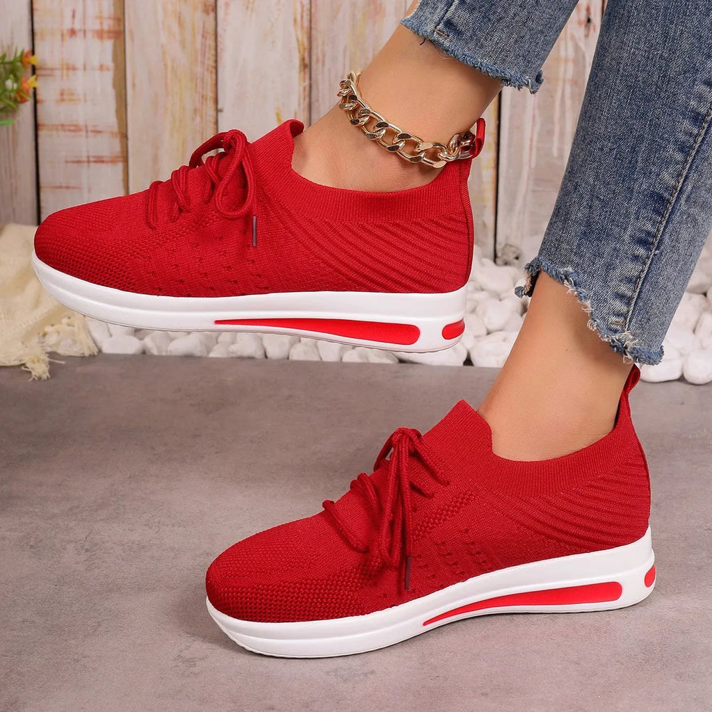 Women's low-top sneakers in black with fly-knit PU upper and front lace-up design.