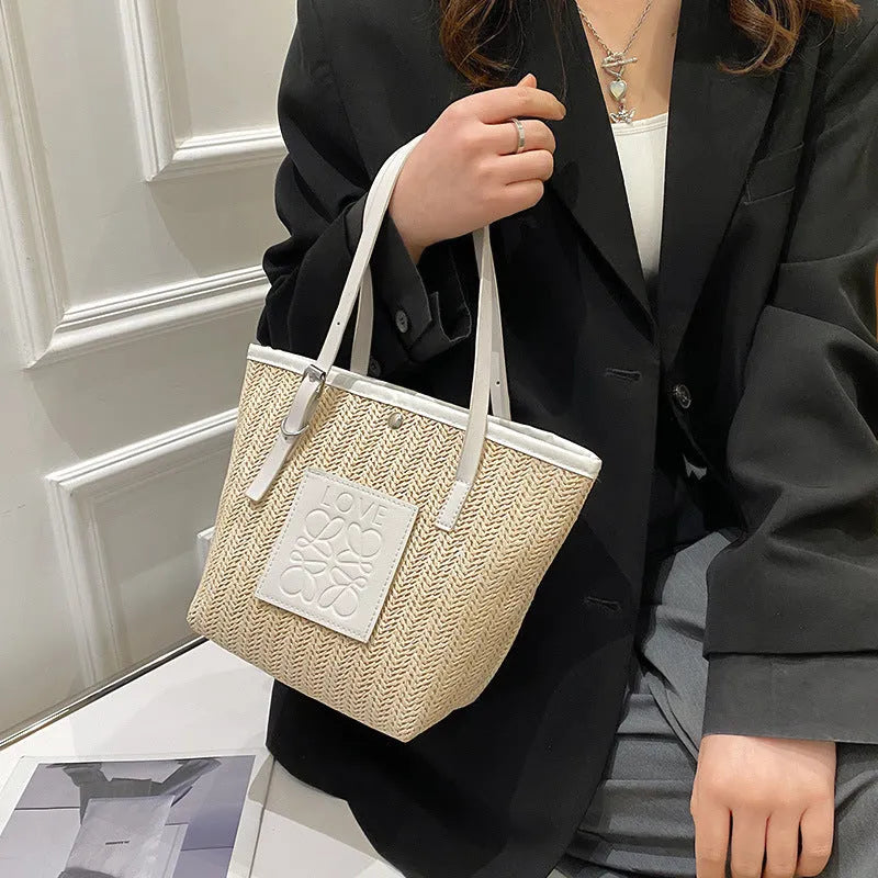 Straw woven women's shoulder bag in black with sewing thread detailing and three-dimensional pockets