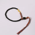 Hand-woven obsidian stone bracelet on a wrist, showing its dark colour and 4mm width.
