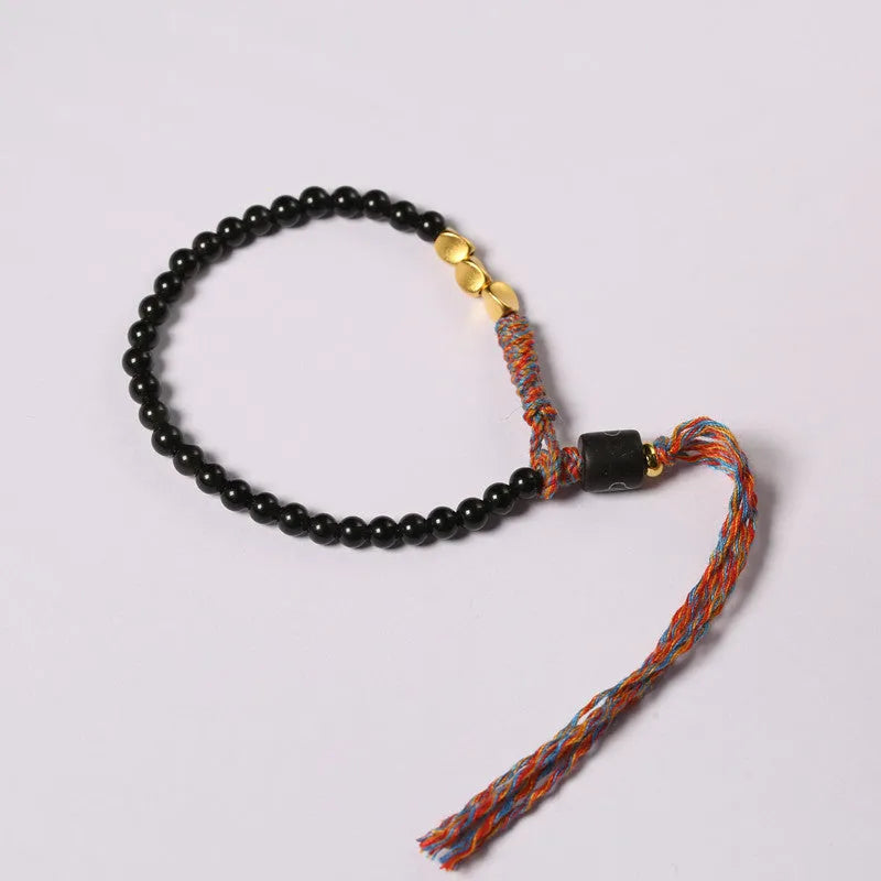 Hand-woven obsidian stone bracelet on a wrist, showing its dark colour and 4mm width.