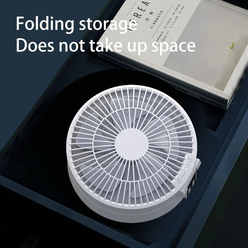 White portable rechargeable folding fan with night light and remote control on a desk