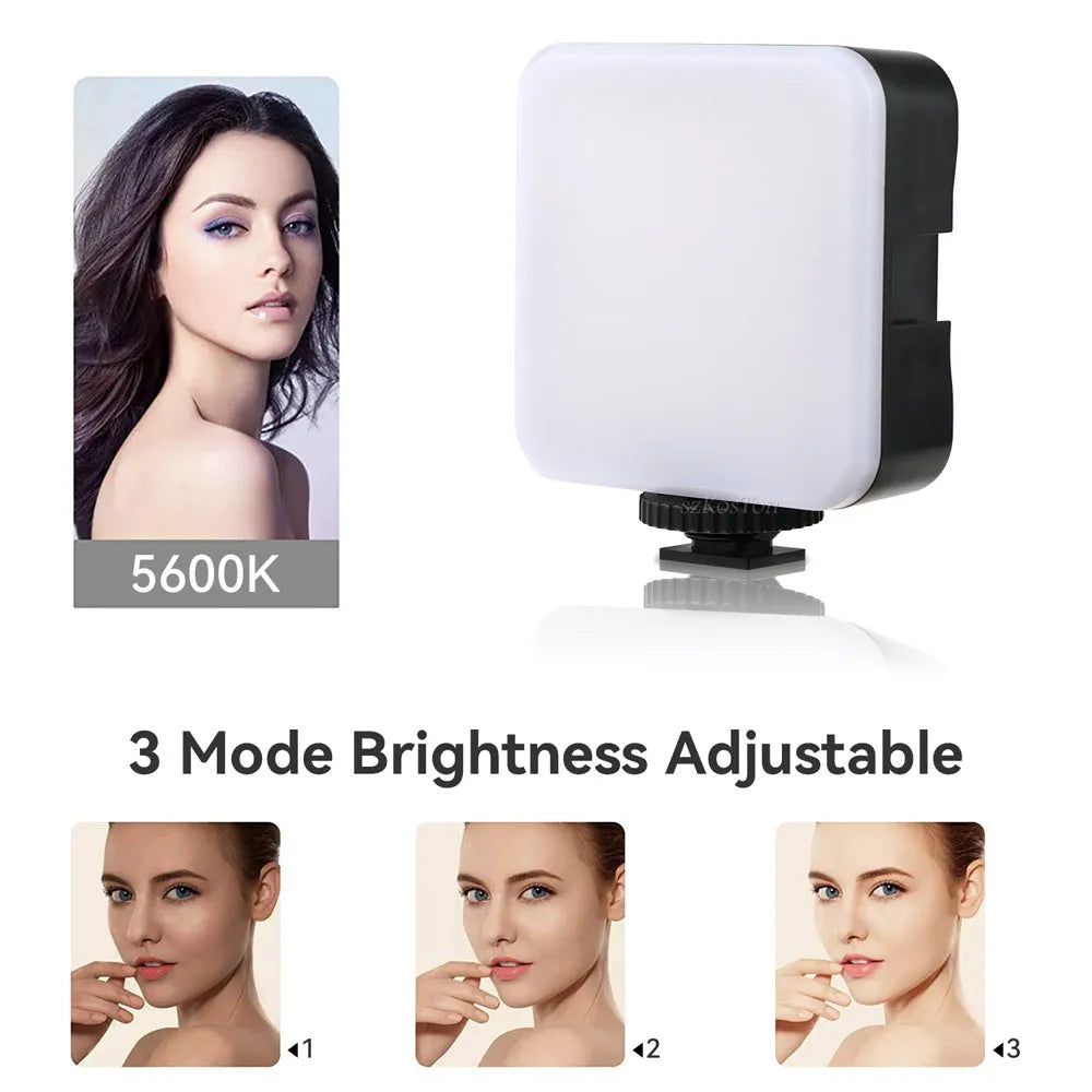 Compact black LED mini square camera flash with hot shoe mount on a small tripod stand.