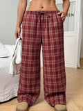 Women's red plaid casual trousers with drawstring waist and patch pockets laid flat