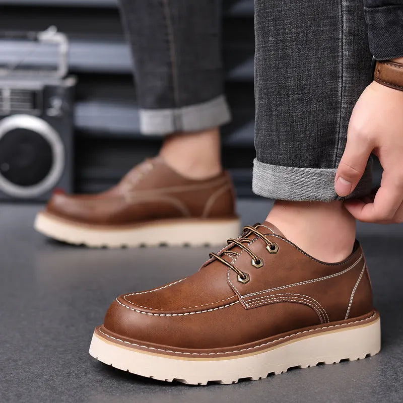 Men's black low-top Martin boots with round toe and rubber sole on a neutral background.