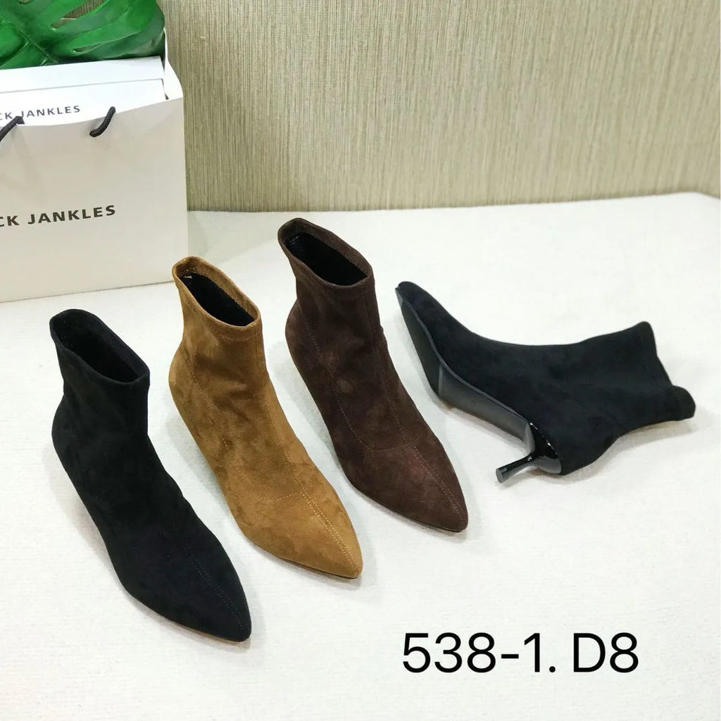 Black women's pointed toe Martin ankle boots with a high stiletto heel on a model.