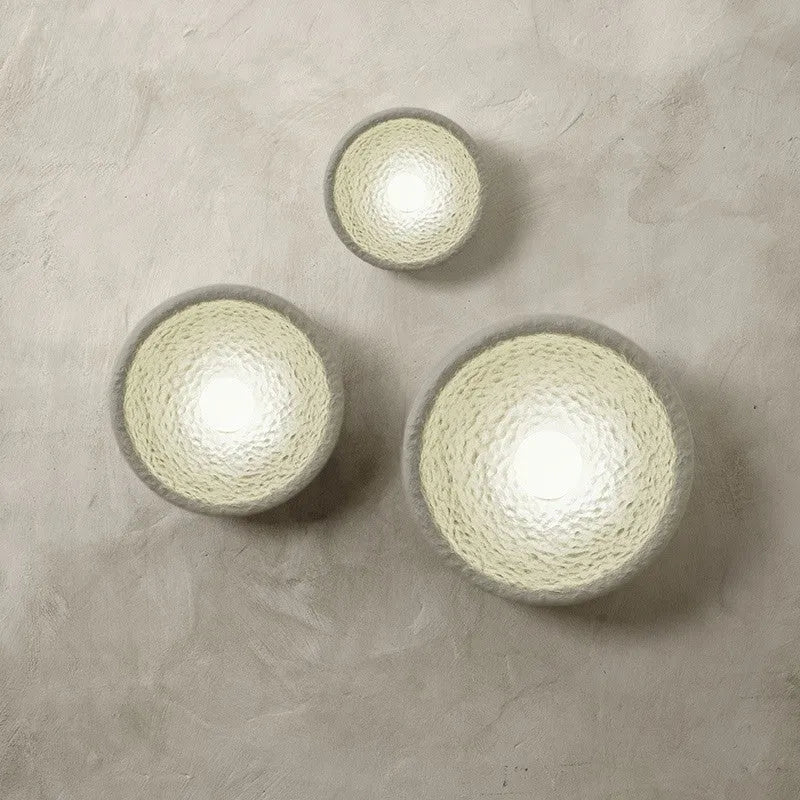 Japanese minimalist wall lamp with a round resin shade, shown in a modern room setting.