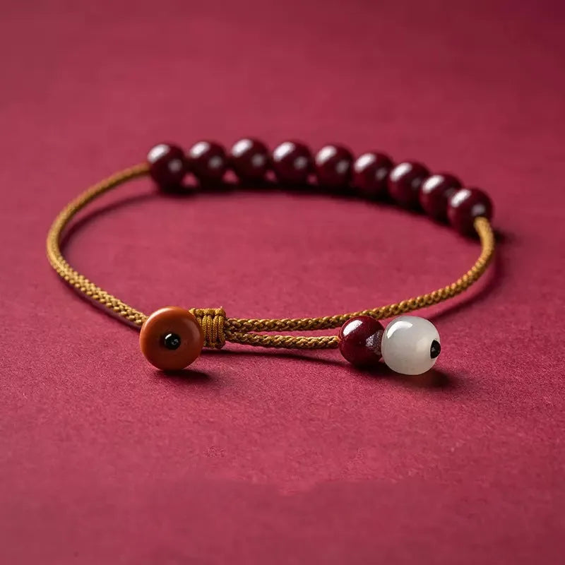 Hand-woven cinnabar and Hetian jade bracelet with geometric design showing natural colour variation