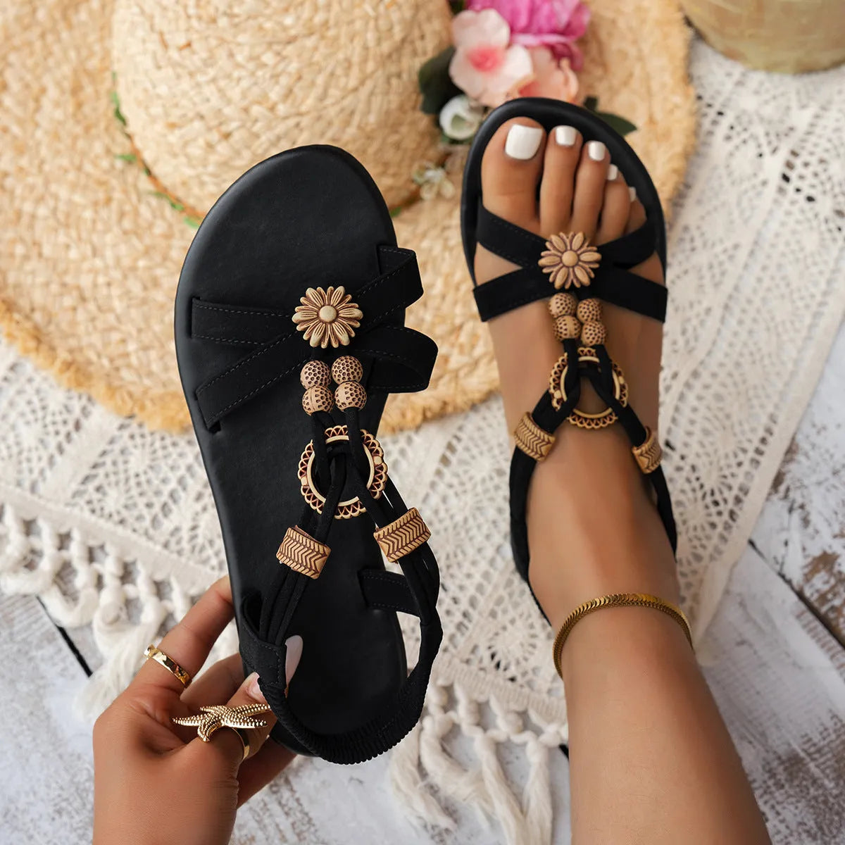 Black women's flat ethnic style beach sandals with beaded weave upper and elastic band.
