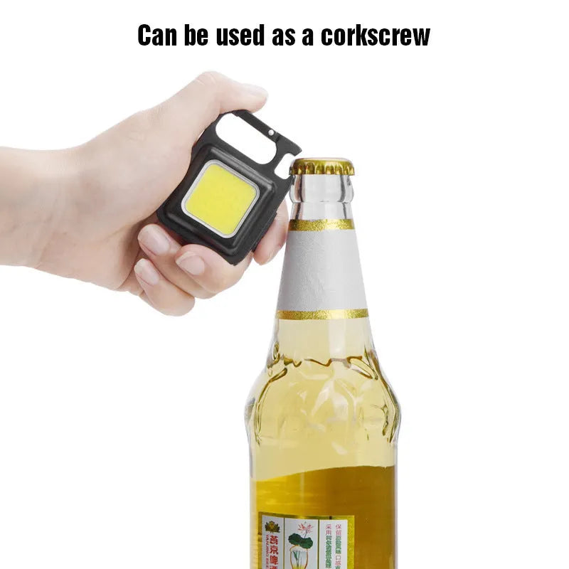 Black aluminium alloy USB rechargeable keychain torch with magnetic base and foldable handle.