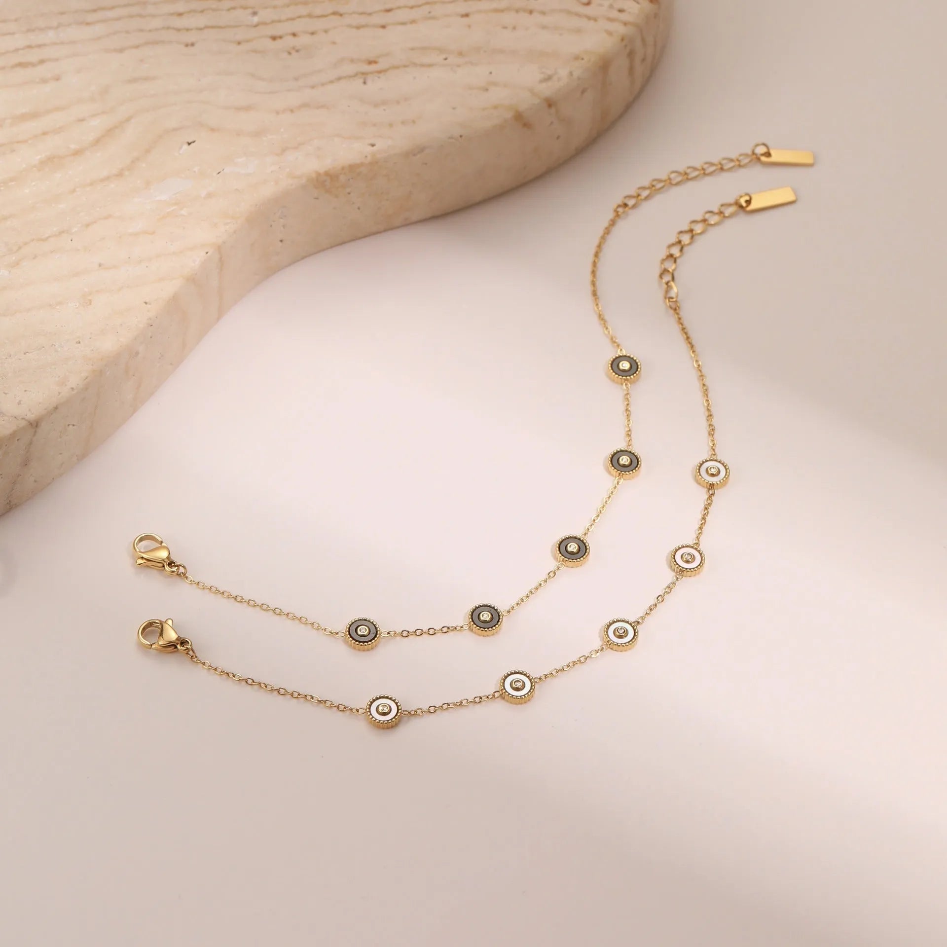 Stainless steel bracelet and necklace set with 18K gold plating and geometric fritillary design