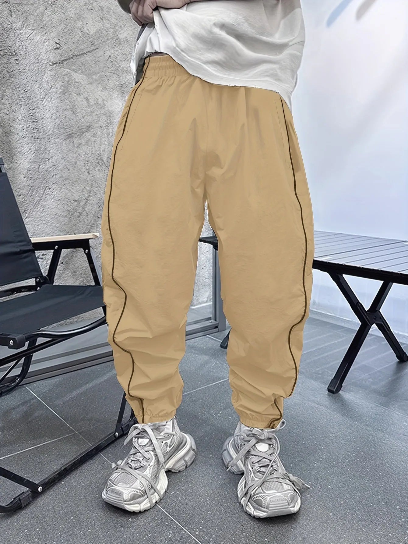Man wearing loose-fit, cropped-length casual trousers in bamboo fibre, shown in khaki colour