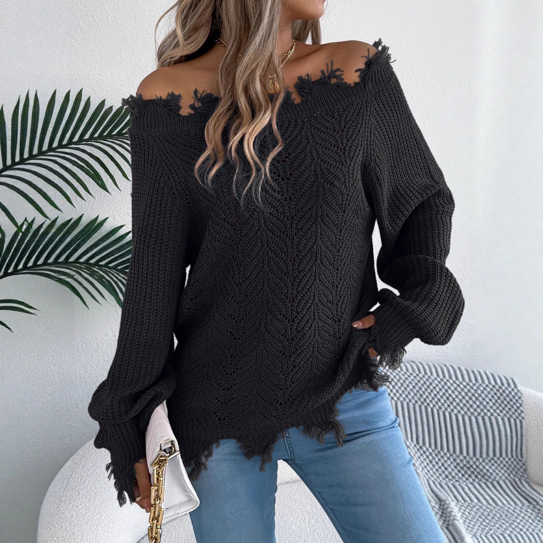 White hollow-out long sleeve pullover sweater with an off-the-shoulder neckline on a hanger.