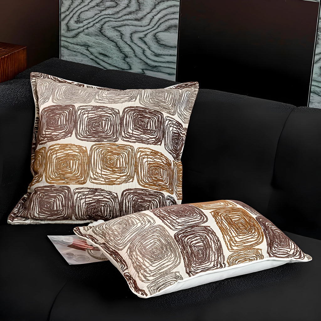 Cream and coffee-coloured abstract coil pattern printed on square polyester velvet pillow cover