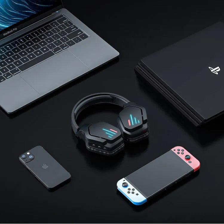 Luminous black wireless gaming headphones with head-mounted design on a desk with included 3.5mm cable and dust bag.
