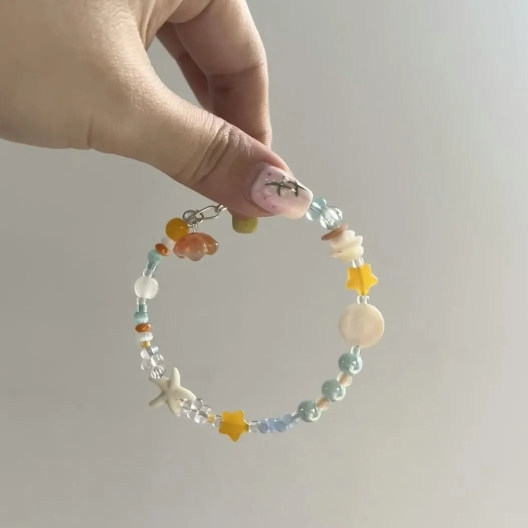Orange alloy bracelet with diamond shape and round decorative elements on wrist