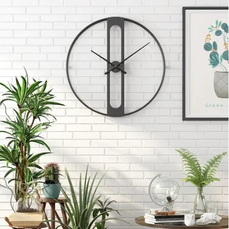 Round metal wall clock with 50cm diameter in black or gold colour on a white wall.