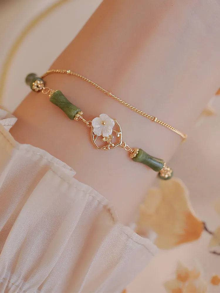 Natural olivine women's bracelet with a double layer twin bells of ireland charm and olive branch detail.