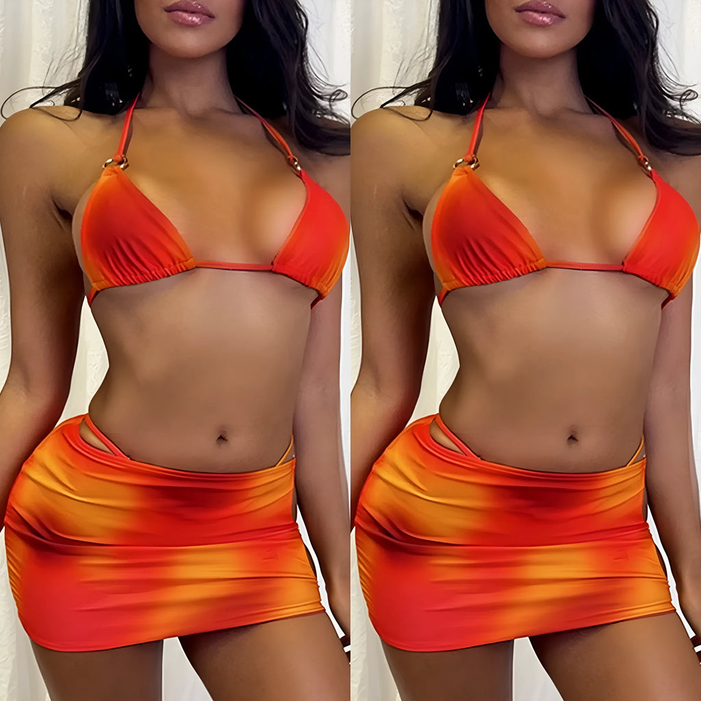 Tie-dye gradient three-piece halter bikini swimsuit set with wrap skirt on a neutral background.