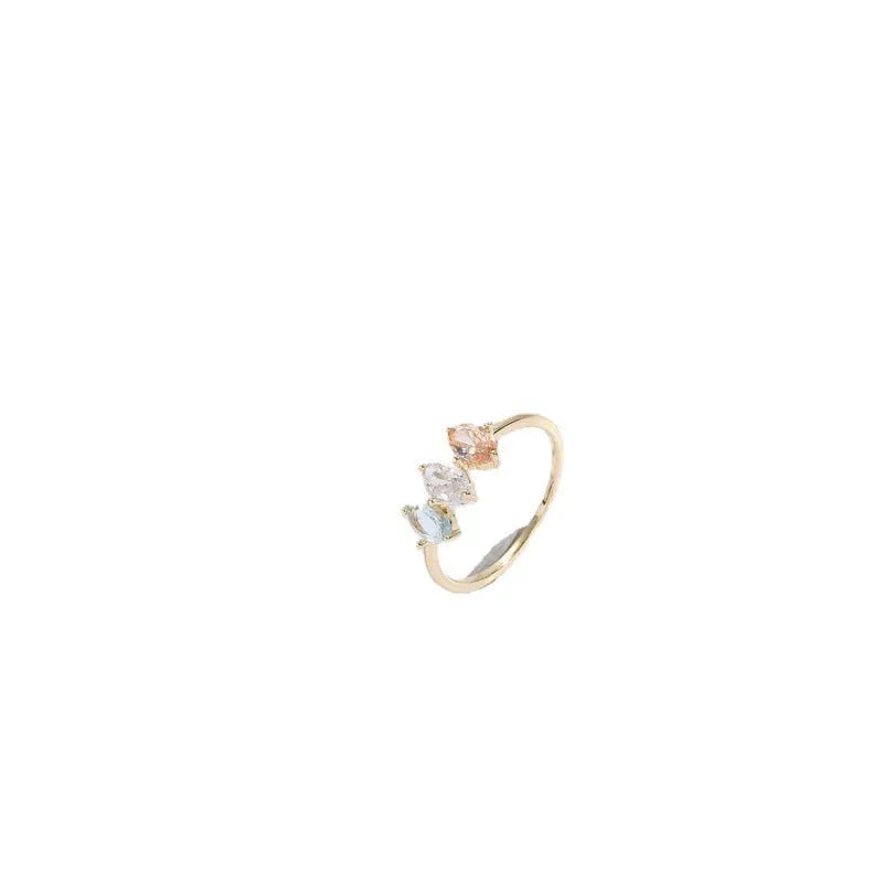 Women's gold-coloured ring with a horse eye design and three coloured zircon stones on a geometric band.