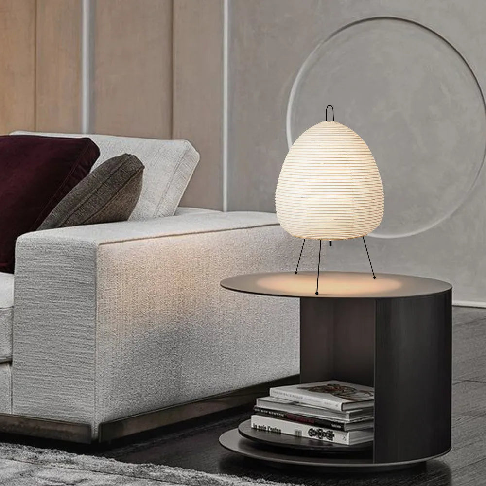 Japanese style rice paper table lamp with aluminium base on a wooden table.