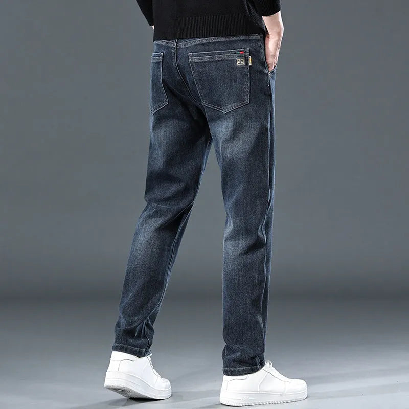 Men's slim straight casual trousers in blue-grey, showing a loose fit and zip fly detail.
