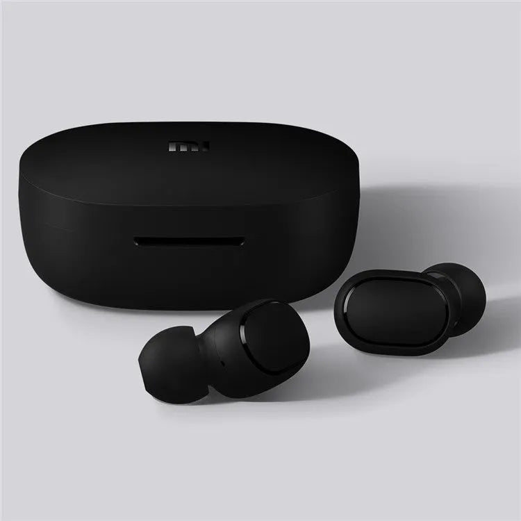 Redmi AirDots black true wireless earbuds next to their compact white charging case.