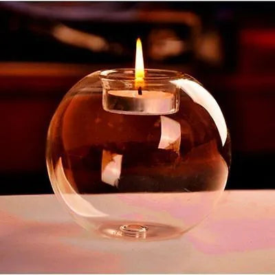 Handmade round hollow glass candle table centrepiece on a wooden surface.