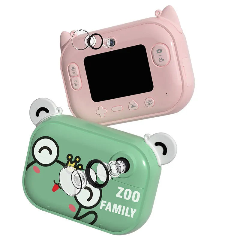 Pink instant print digital camera with 2.4-inch screen shown with printing paper and lanyard