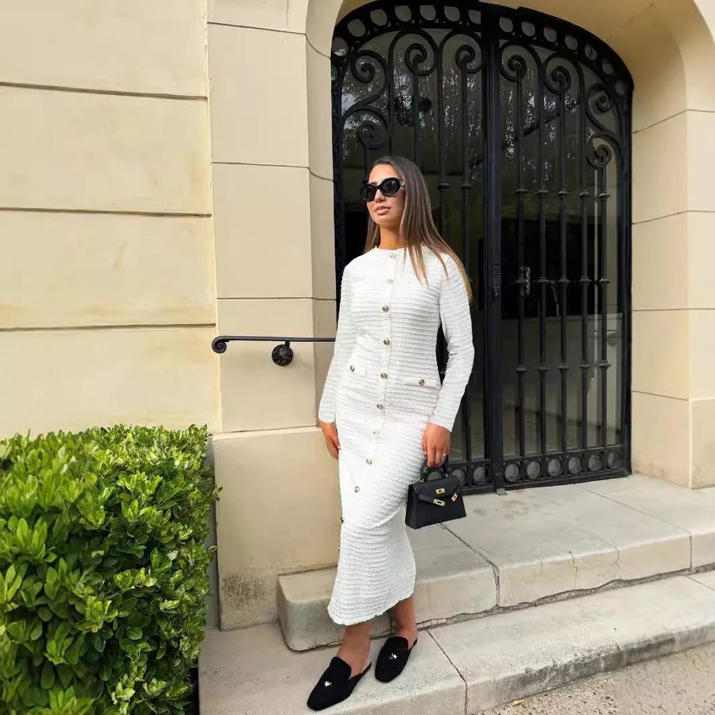 A woman wearing a black French retro slim fit knitted long sleeve dress with button detail.