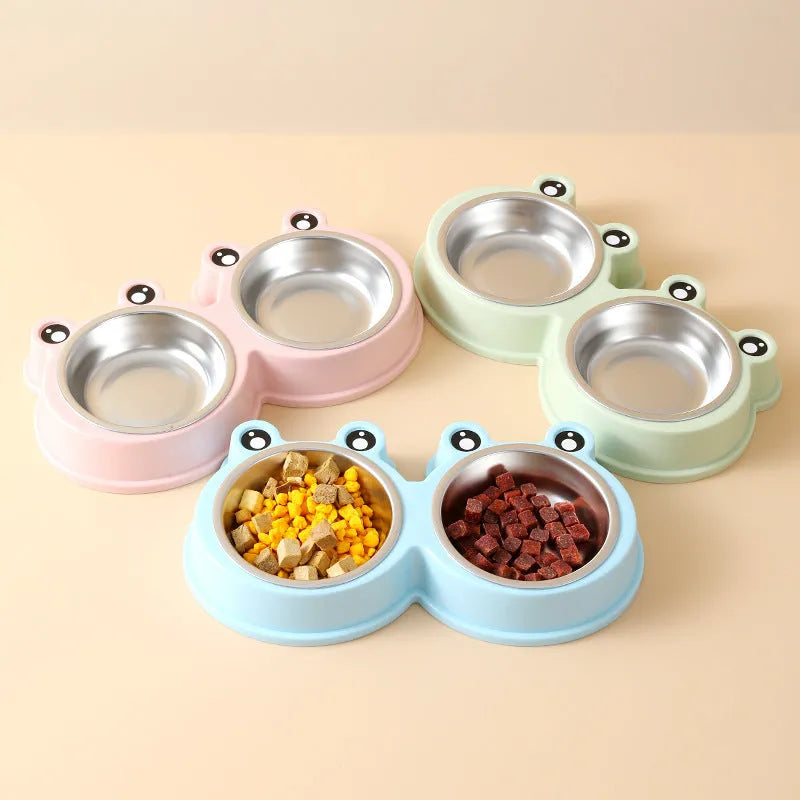 Blue stainless steel double pet bowl with frog design, showing separate food and water compartments on a non-slip base.