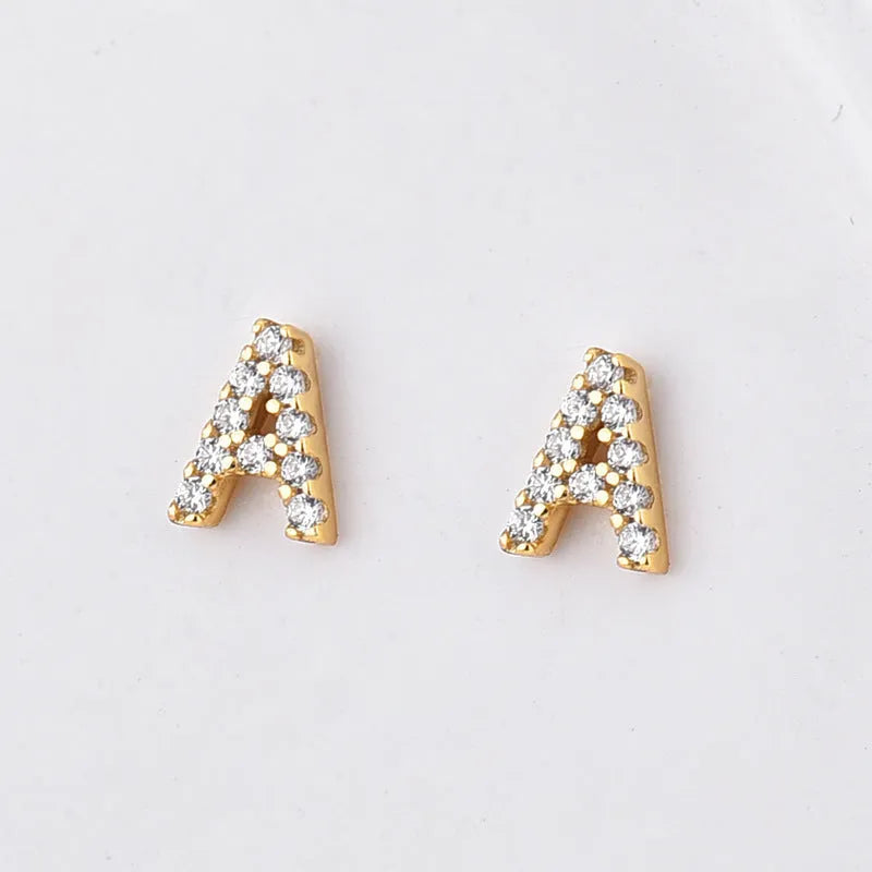 Gold plated alphabet letter earrings on a white background showing the full A-Z set with zircon detail.