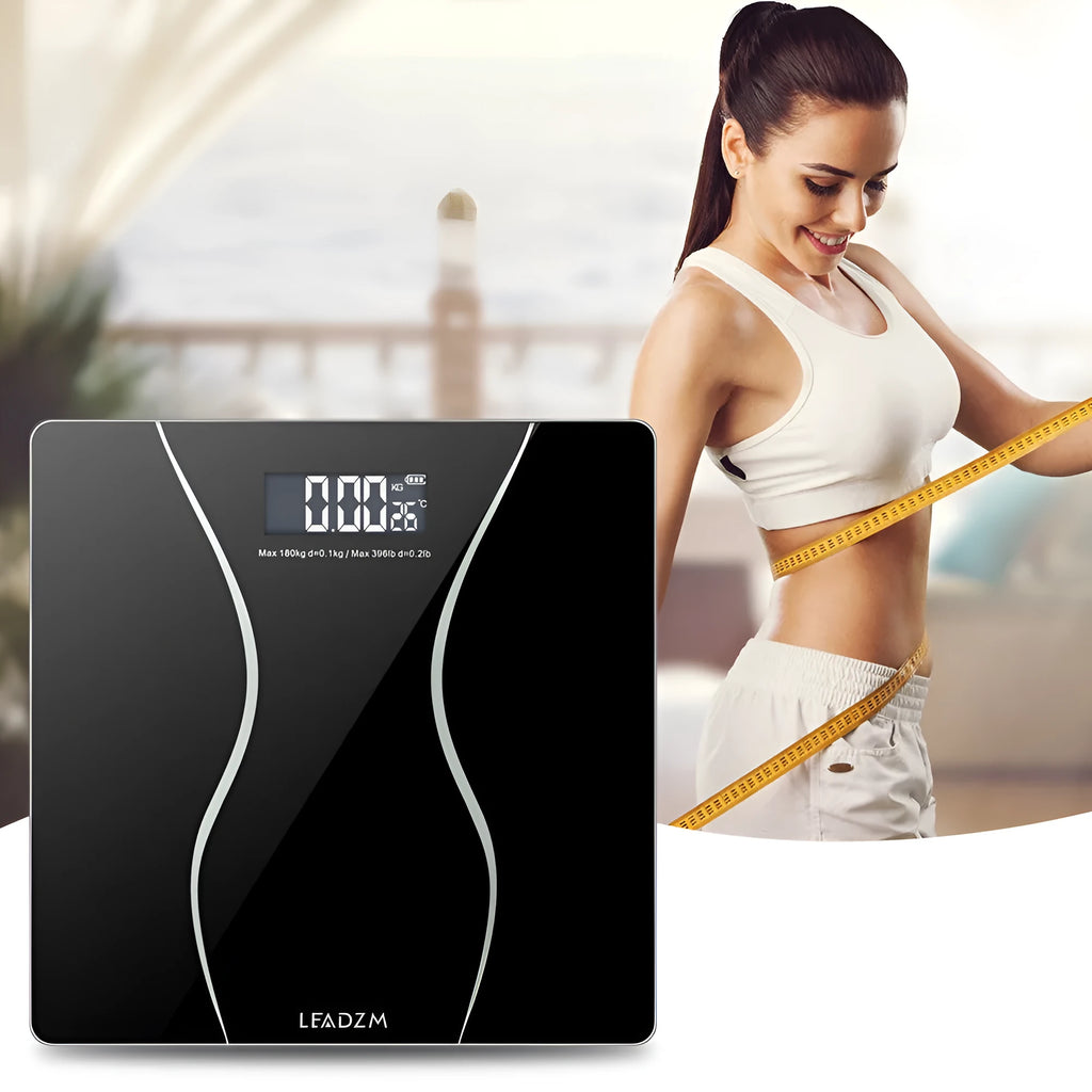 Black electronic bathroom scale with digital display on tempered glass platform