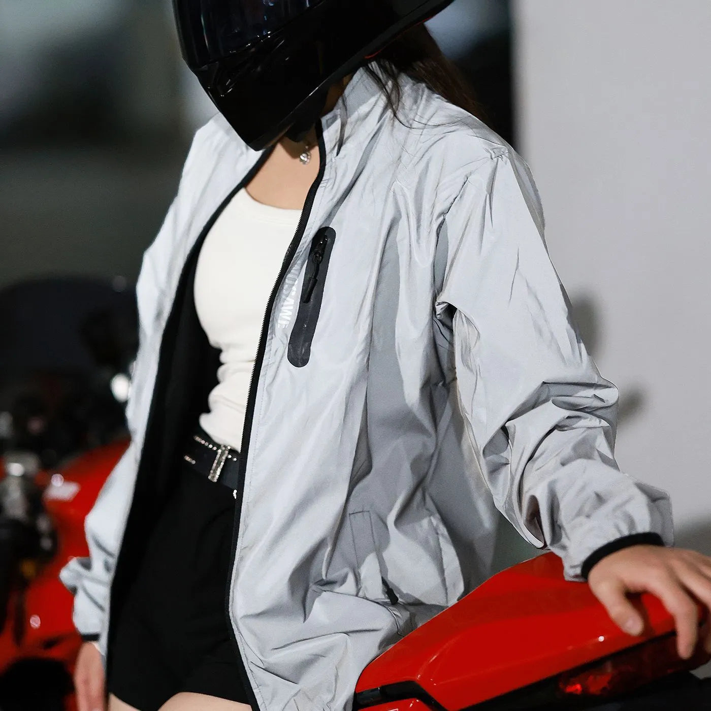 Silver waterproof polyester long sleeve top shown on a hanger.