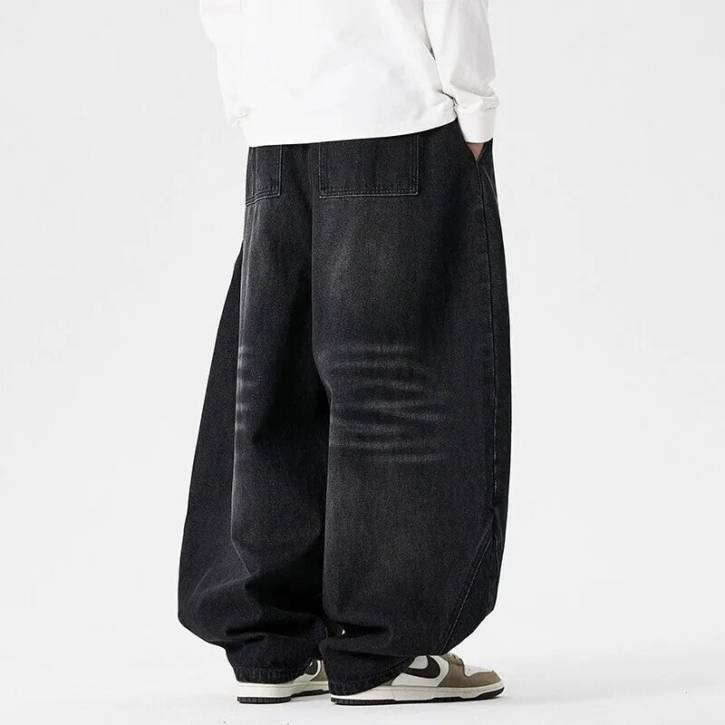 Man wearing light blue plus-size wide-leg casual denim jeans with a baggy fit and straight leg opening.