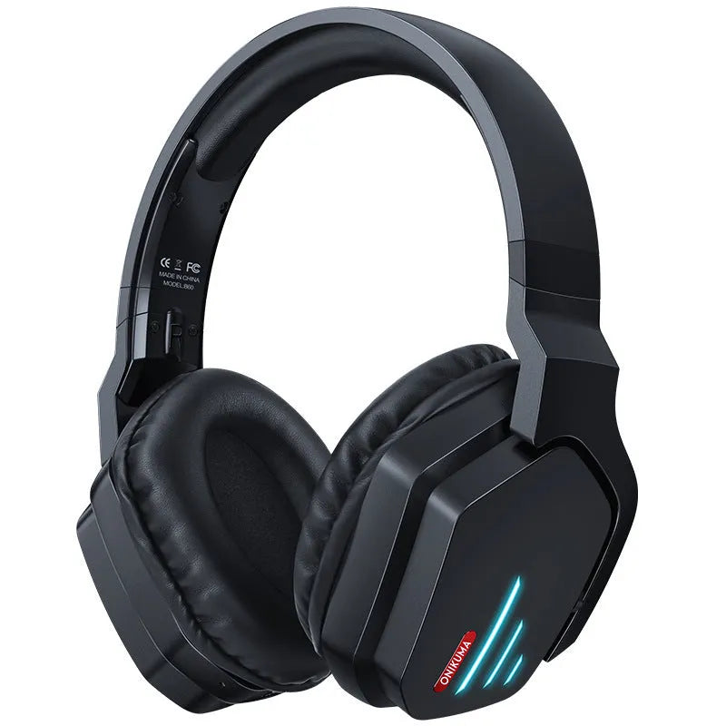 Luminous black wireless gaming headphones with head-mounted design on a desk with included 3.5mm cable and dust bag.