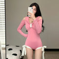 Women's long sleeve one-piece swimsuit in black or pink with polyester fibre construction