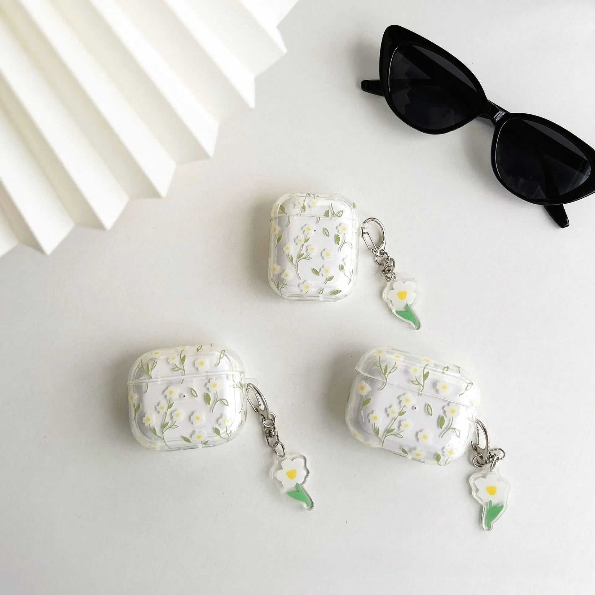 Transparent white floral patterned soft TPU protective case for Apple AirPods on a table.