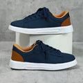 Beige brown casual platform sneakers with cross strap detail and rubber sole.