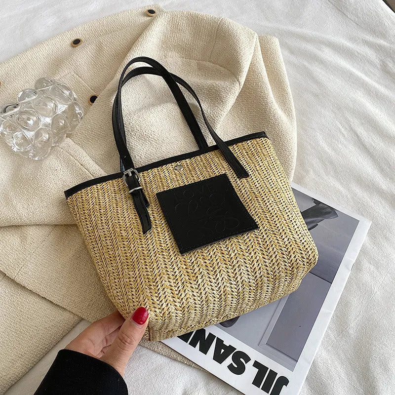 Straw woven women's shoulder bag in black with sewing thread detailing and three-dimensional pockets