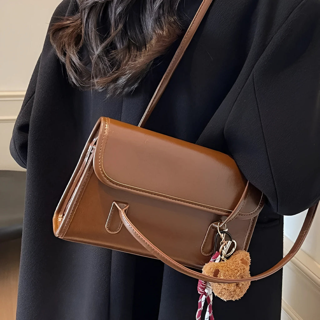 Brown structured women's PU shoulder bag with double straps, a pendant, and a horizontal square shape.