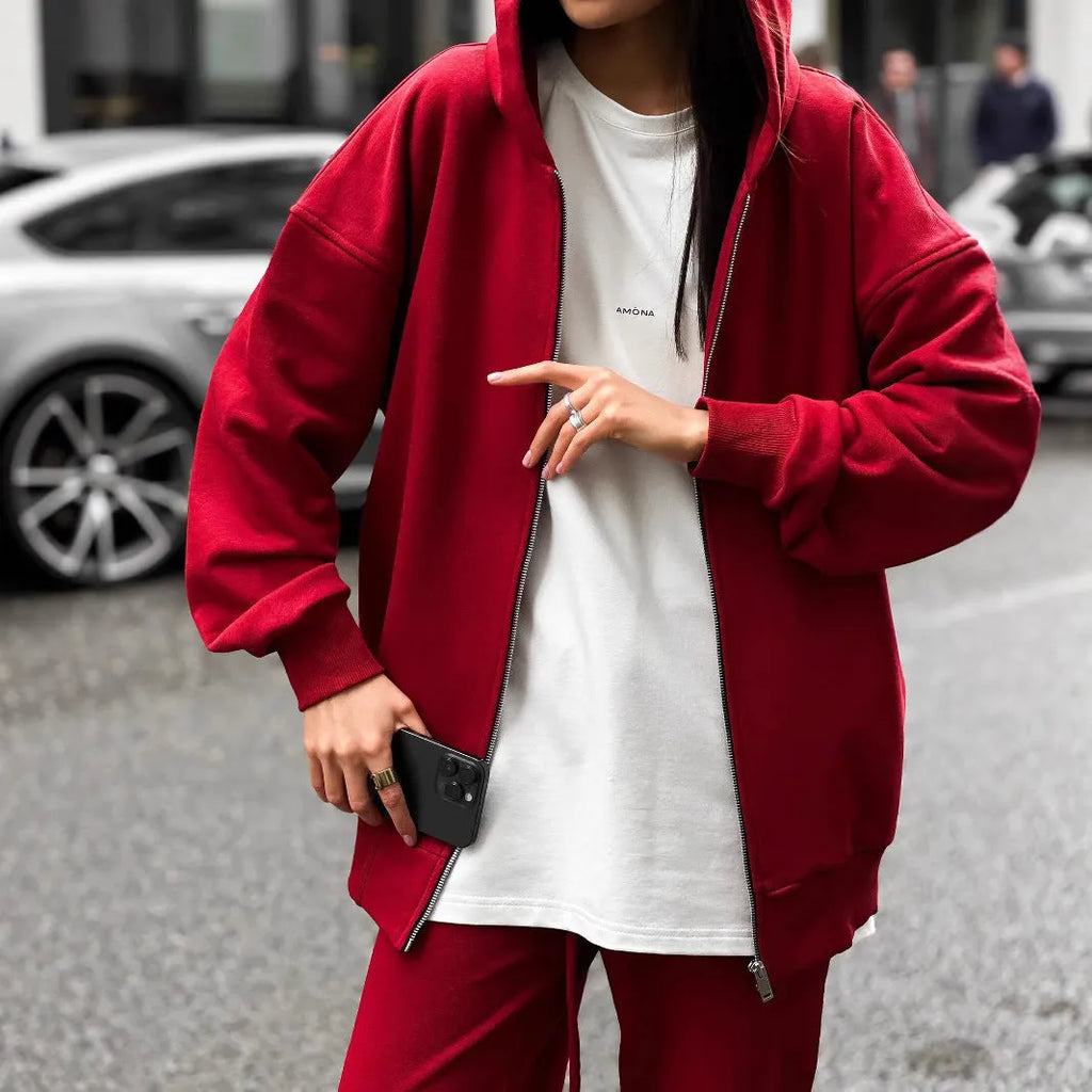 Red loose fit two-piece suit comprising a long-sleeved coat and trousers on a rack.
