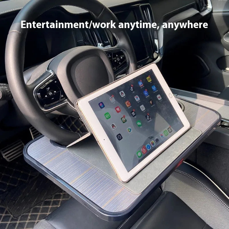 Foldable black car laptop stand with integrated drink holder placed on steering wheel